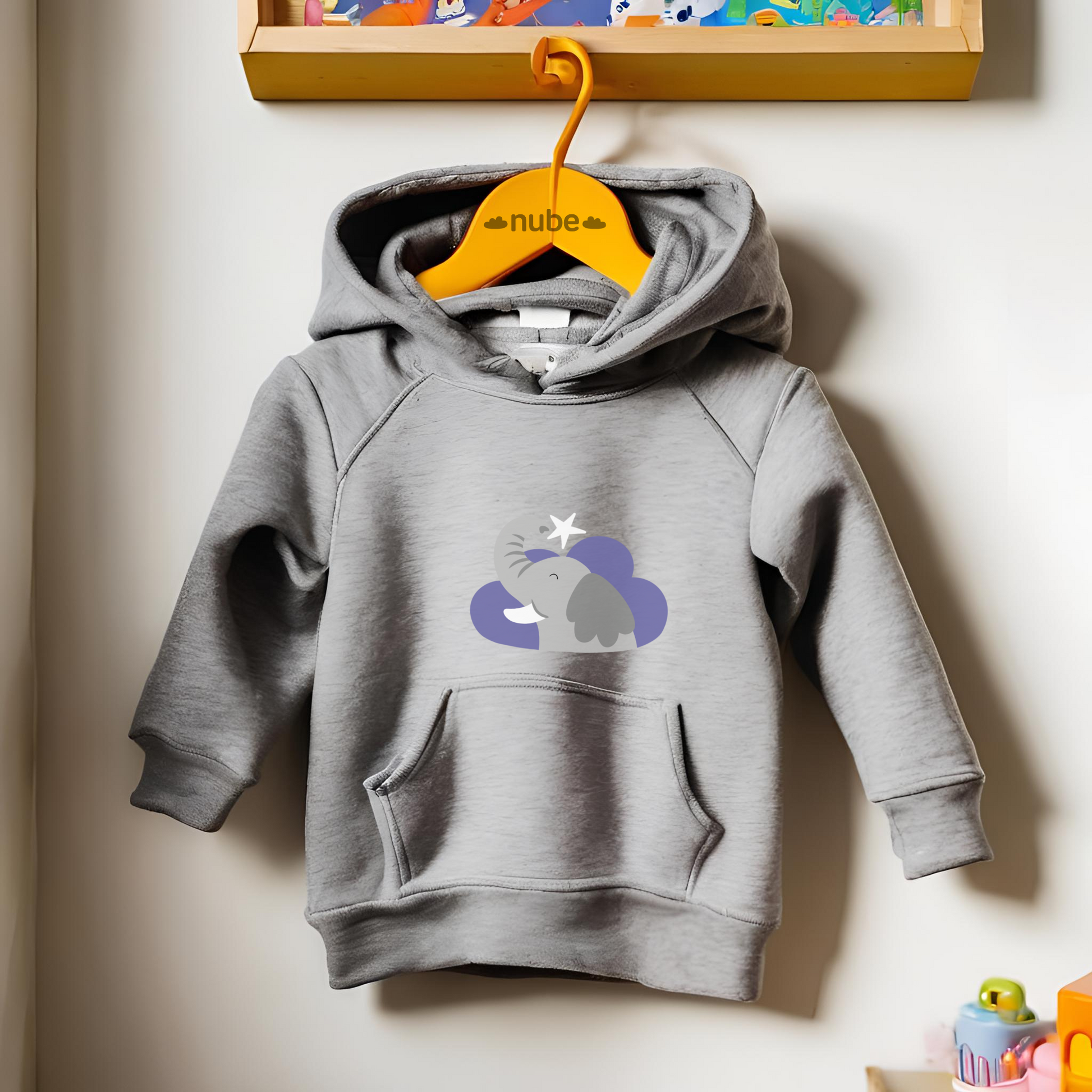 Sudadera tipo hoodie gris  colgada en un gancho con diseño de Clementino el Elefante de la marca de ropa Nube dentro de una nube morada y una estrella blanca a lado.