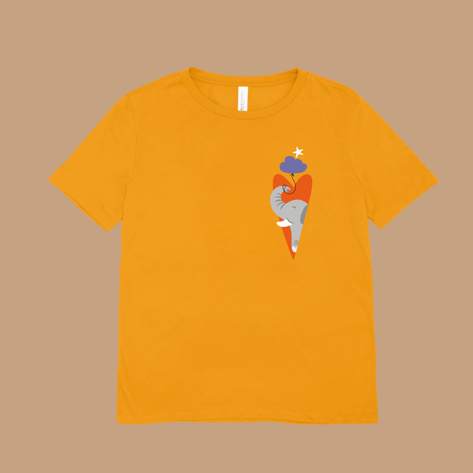 Playera amarila con estampado del diseño del elefante clementino de la marca de ropa nube dentro de un corazón naranja y con un globo morado amarrado en su trompa. Arriba lo guía una estrella blanca.