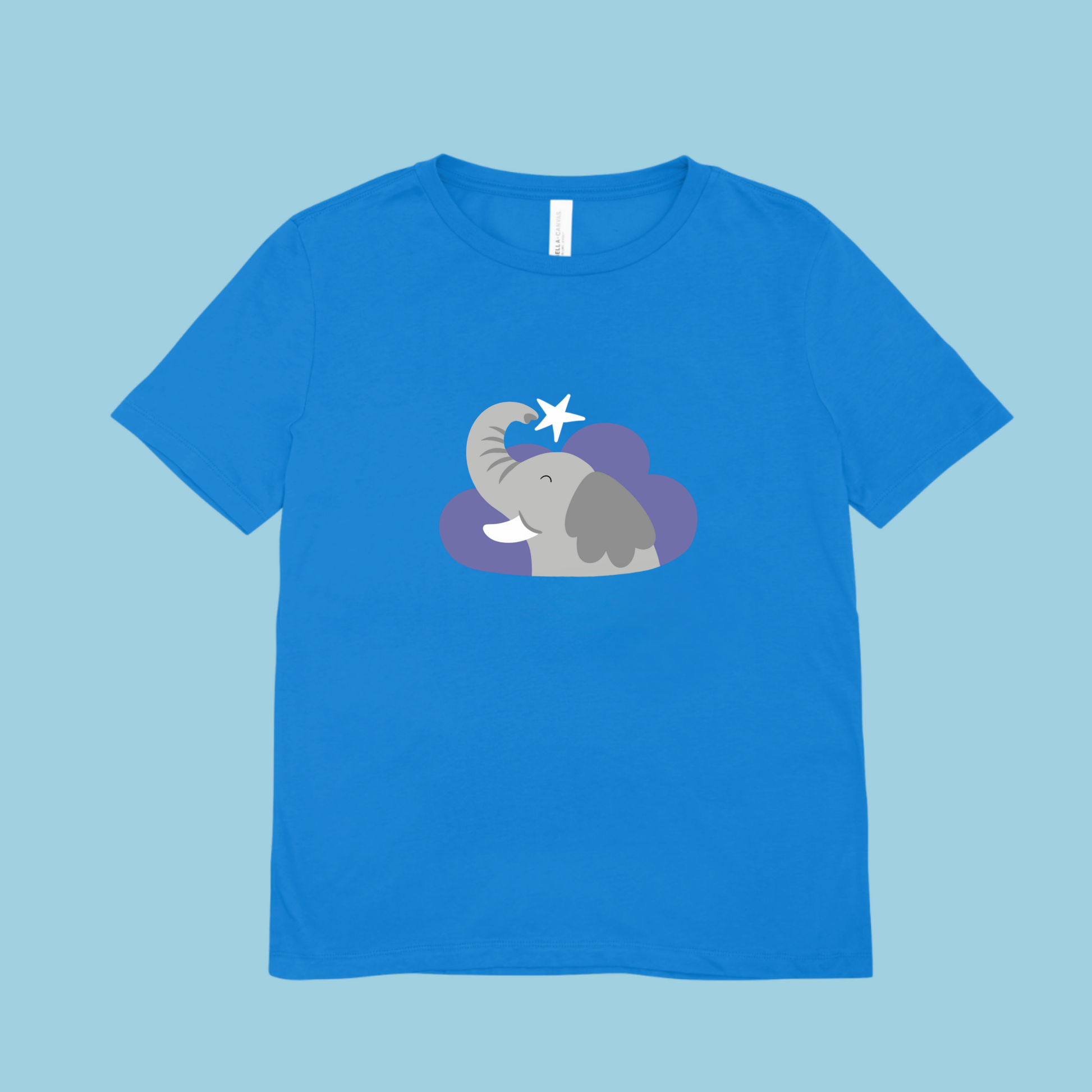 Playera amarilla con estampado del diseño del elefante clementino de la marca de ropa nube dentro de una nube morada. Arriba lo guía una estrella blanca.