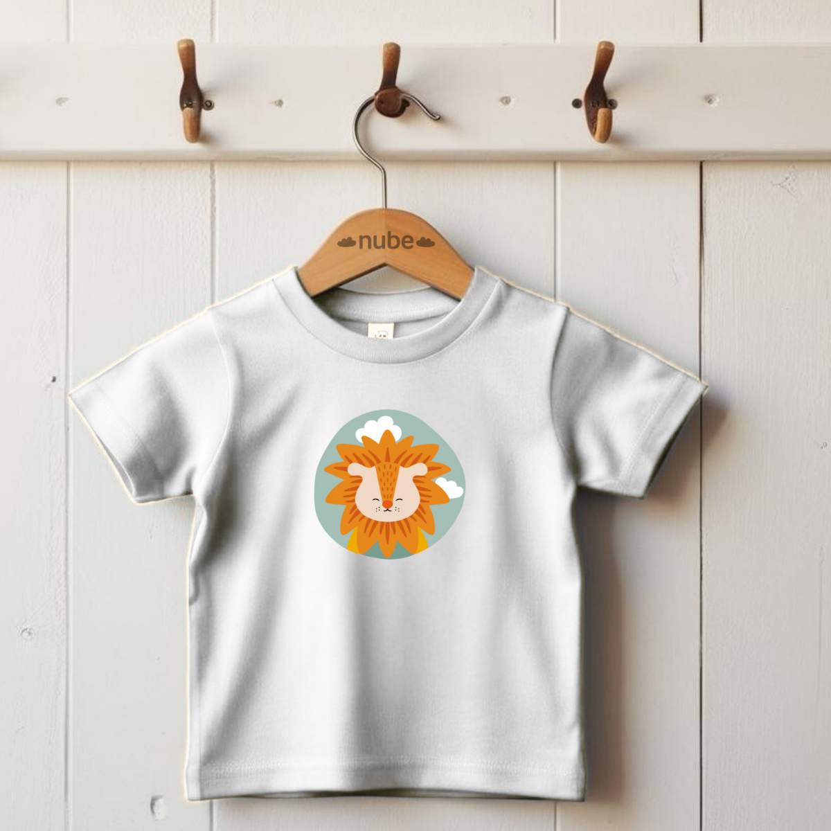 Playera blanca colgada en gancho con estampado del retrato del león Sabino de la marca de ropa nube dentro de un círculo verde con nubes.
