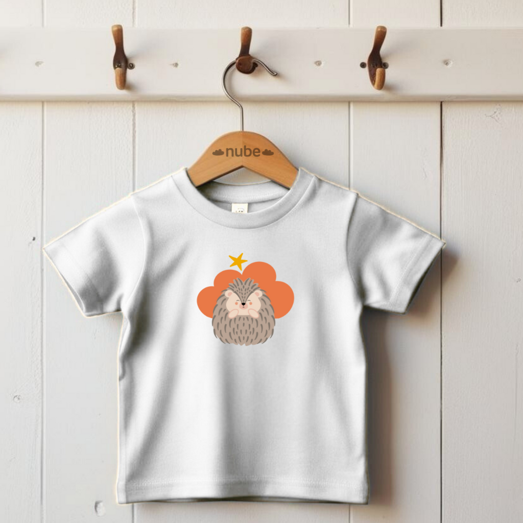 Playera blanca colgada en un gancho con estampado del diseño del puercoespin Filomeno de la marca Nube en una Nube color naranja y una estrella amarilla