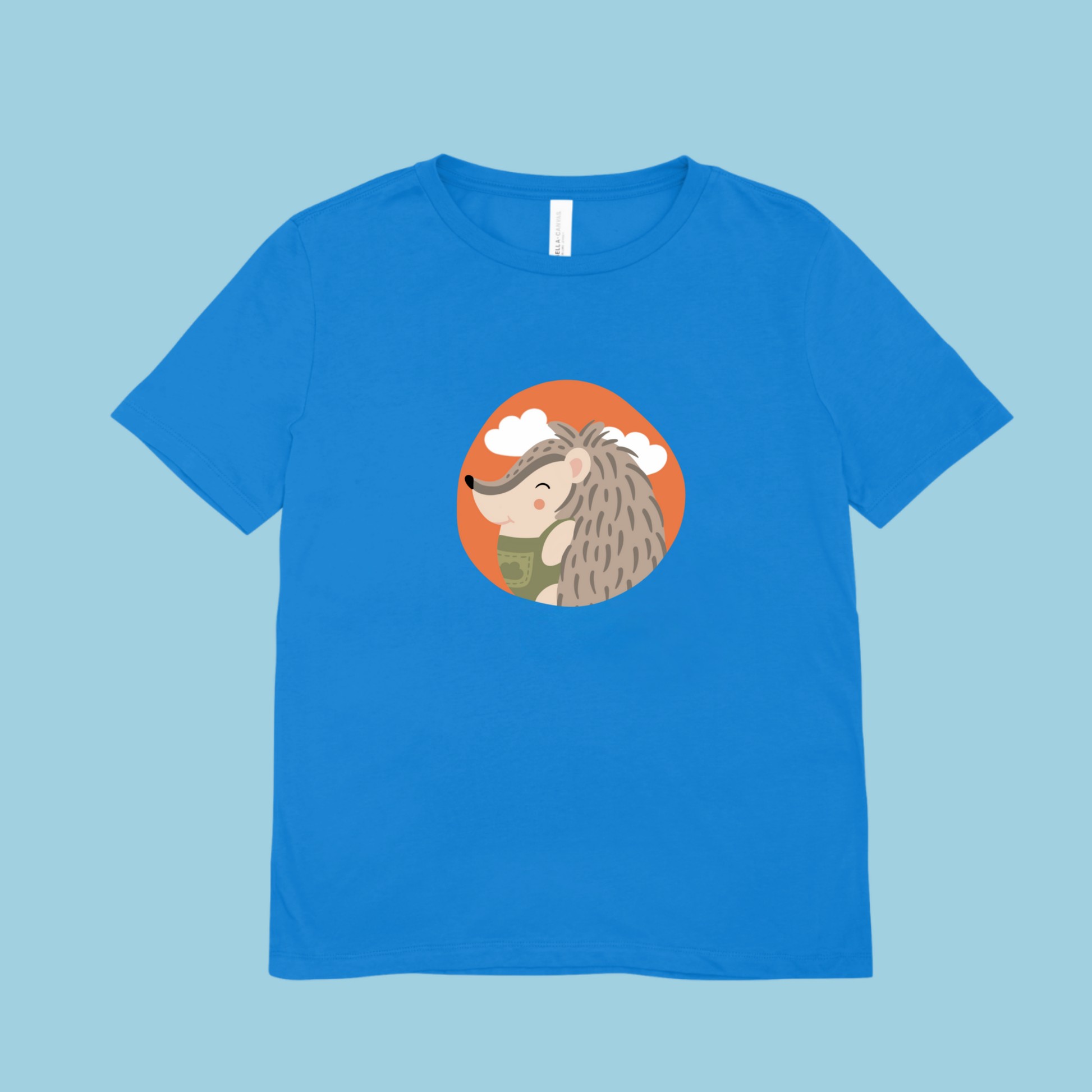 Playera azul con estampado del retrato del puercoespin Filomeno de la marca de ropa Nube con un traje verde dentro de un círculo naranja con nubes.