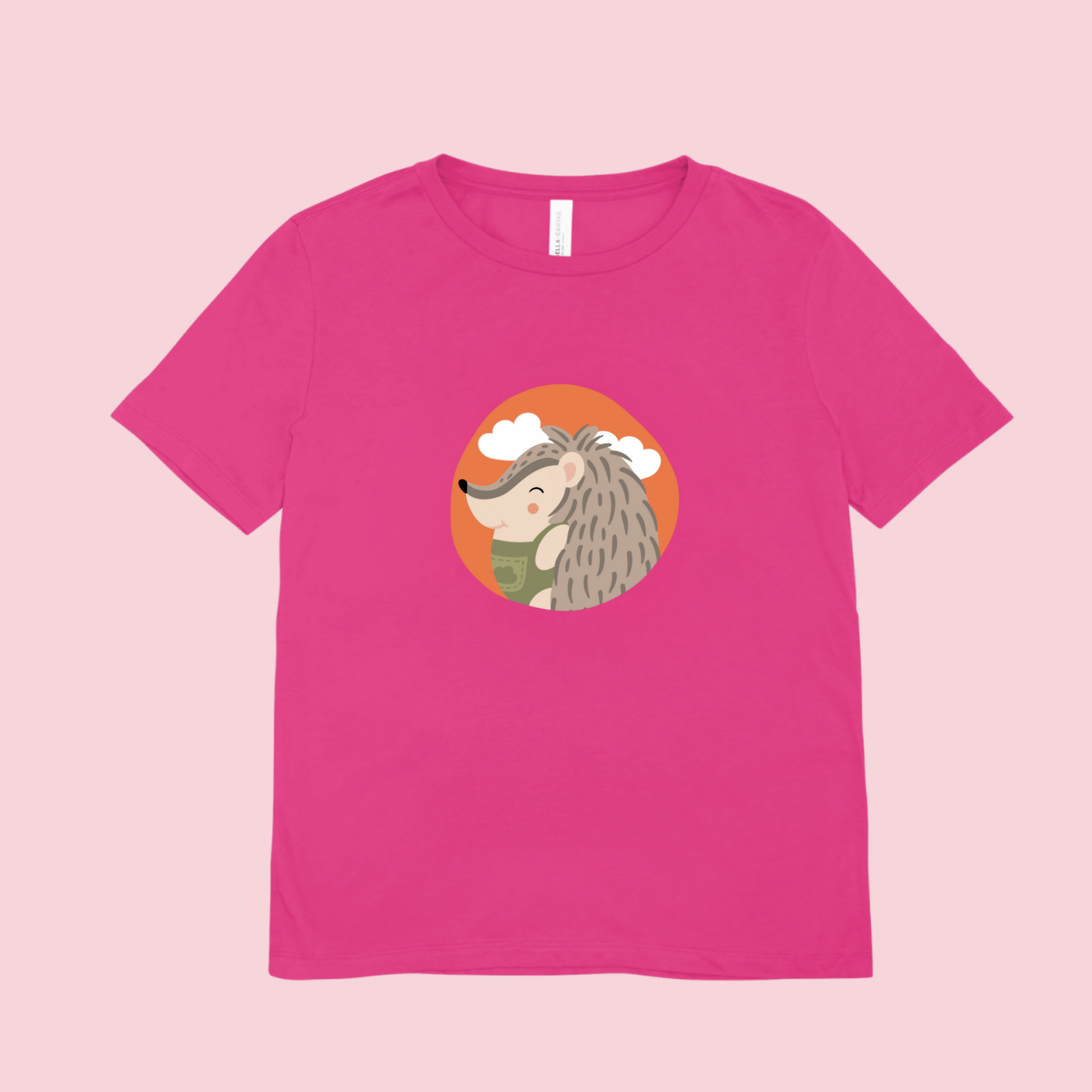 Playera rosa fucsia con estampado del retrato del puercoespin Filomeno de la marca de ropa Nube con un traje verde dentro de un círculo naranja con nubes.