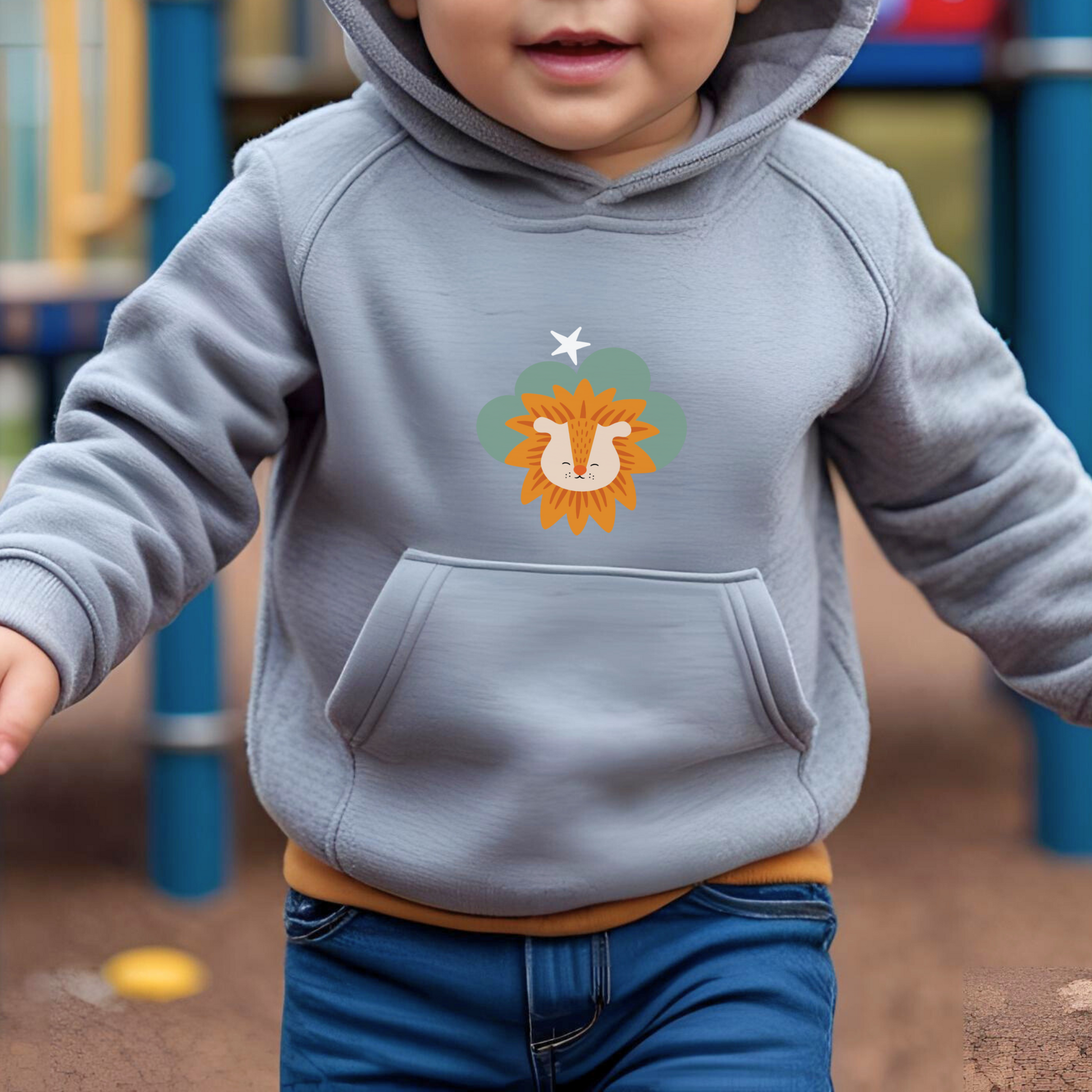Toddler jugando en el parque con sudadera tipo hoodie gris con diseño de Sabino el León de la marca de ropa Nube dentro de una nube verde y una estrella blanca a lado.