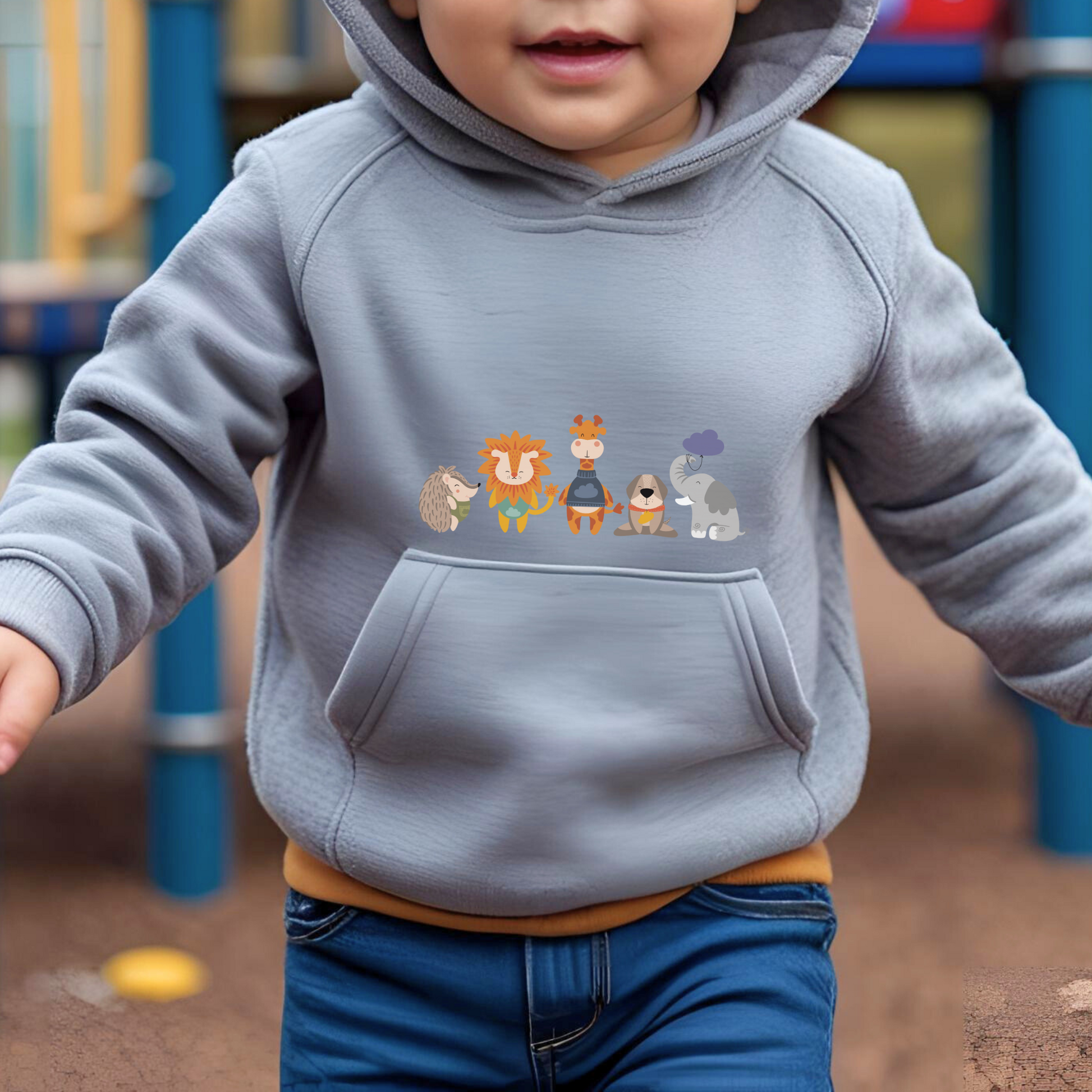 Toddler jugando en el parque con sudadera tipo hoodie gris con diseño de la manada  de la marca de ropa Nube: Filomeno el puercoespín, Sabino el león, Lázaro la jirafa, Leandro el perro y Clementino el elefante.