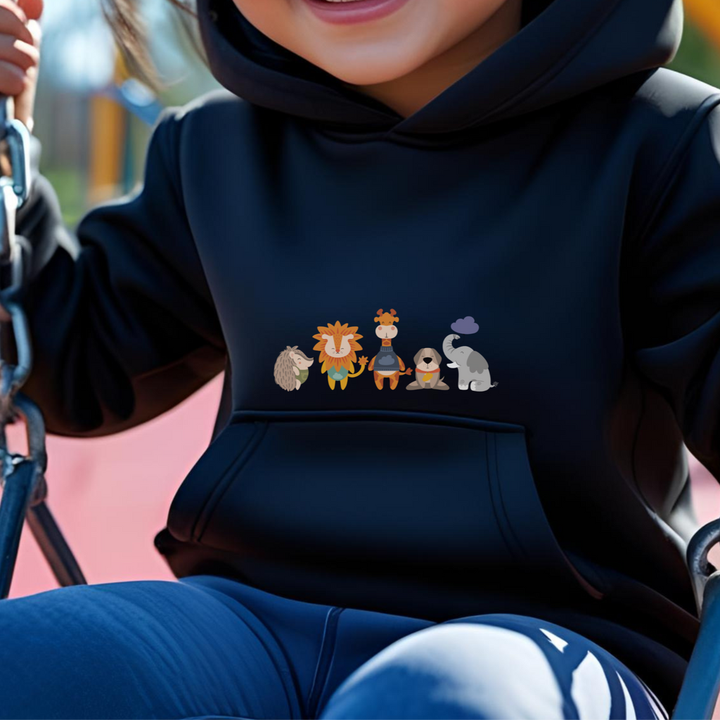 Toddler jugando en el parque con sudadera tipo hoodie negra con diseño de la manada  de la marca de ropa Nube: Filomena el puercoespín, Sabino el león, Lázaro la jirafa, Leandro el perro y Clementina la elefanta.