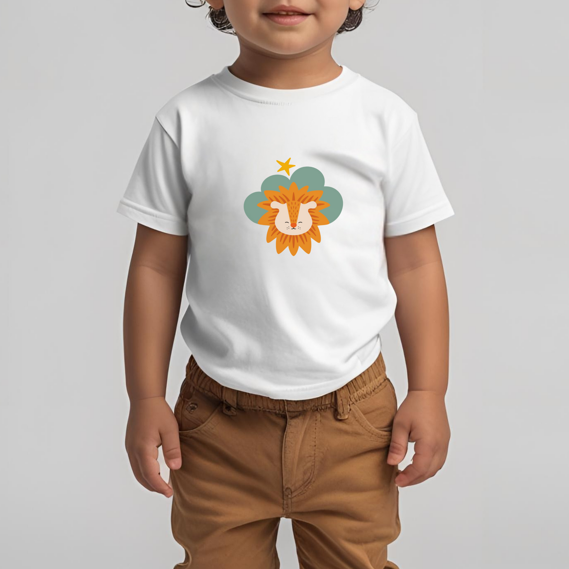 Toddler con pantalón café y playera blanca de la marca de ropa nube con estampado de león Sabino en una Nube color verde y una estrella amarilla