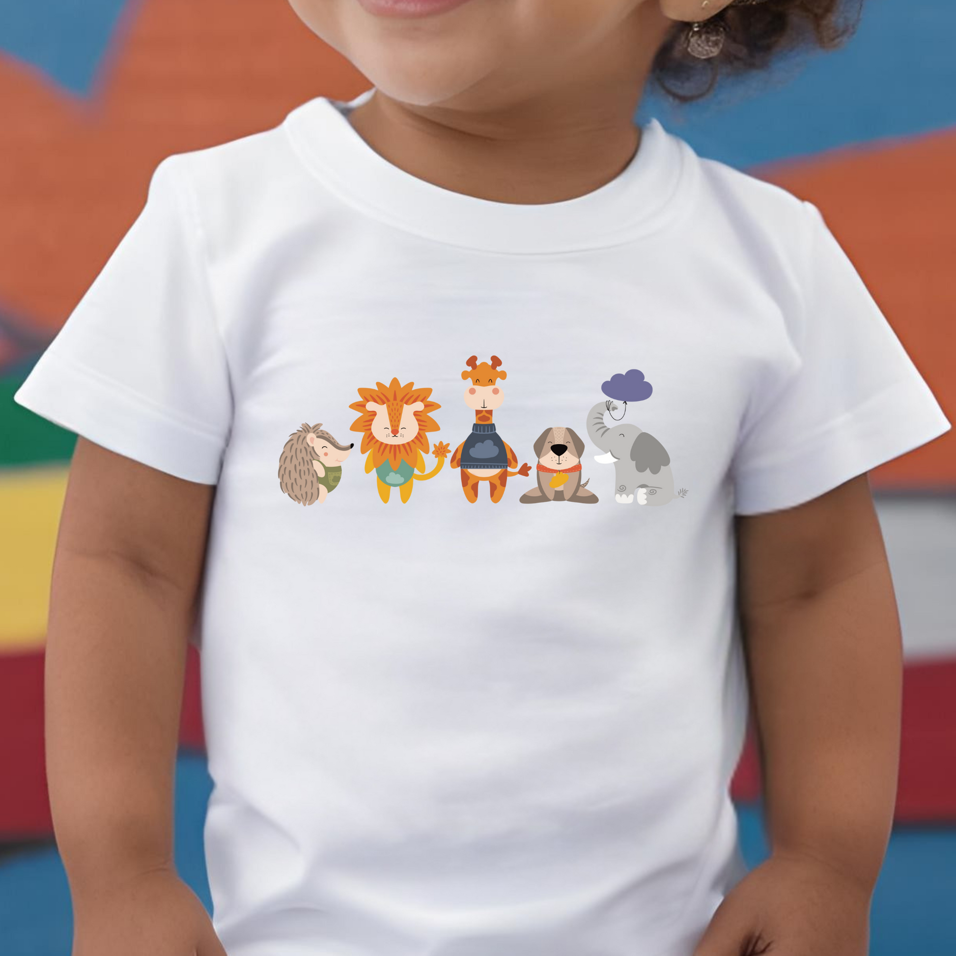 Toddler con playera blanca con diseño de la manada  de la marca de ropa Nube: Filomena el puercoespín, Sabino el león, Lázaro la jirafa, Leandro el perro y Clementina la elefanta.