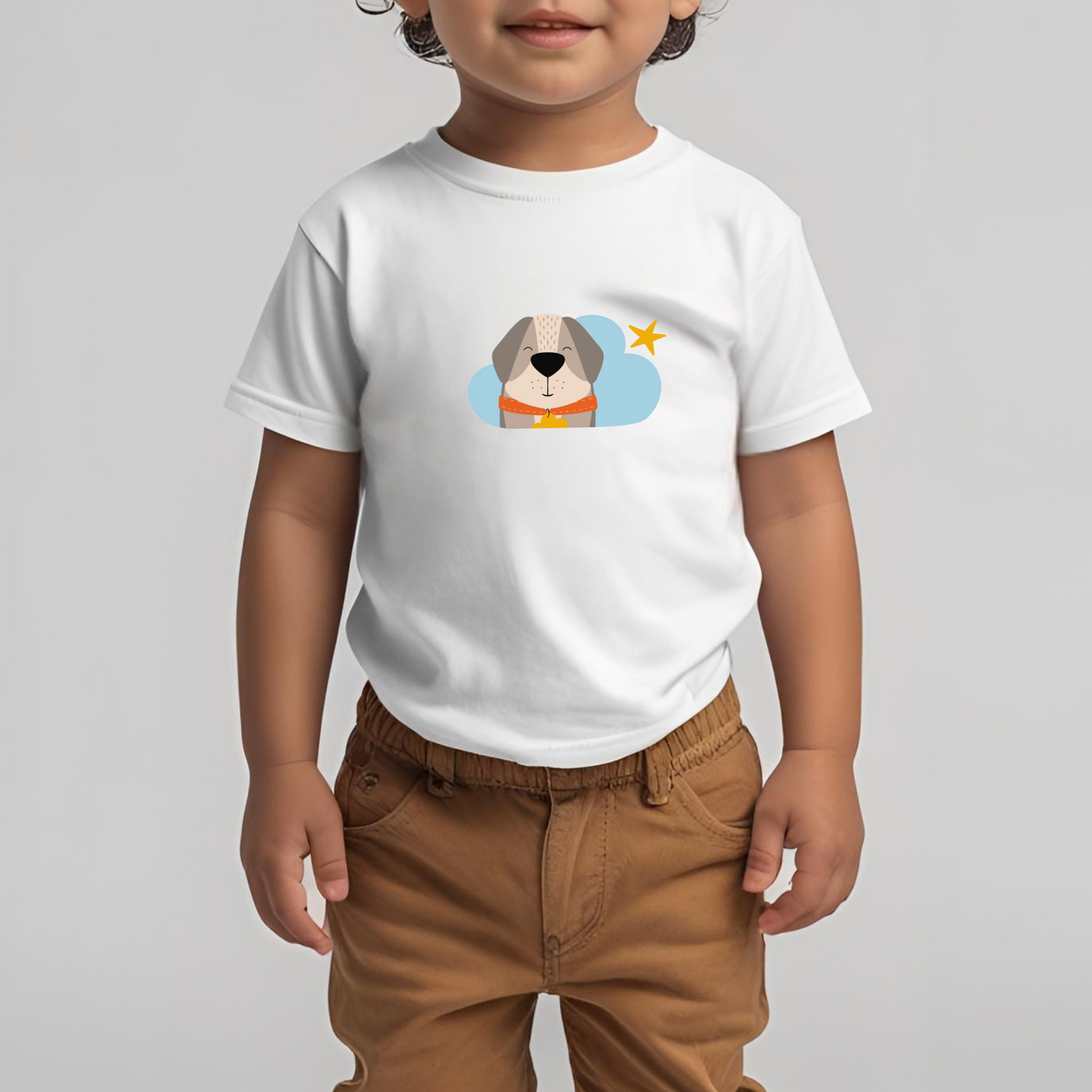 Toddler con pantalones cafés con playera blanca de la marca de ropa nube con estampado del perro Leandro con collar naranja y placa amarilla en una Nube color azul y una estrella amarilla