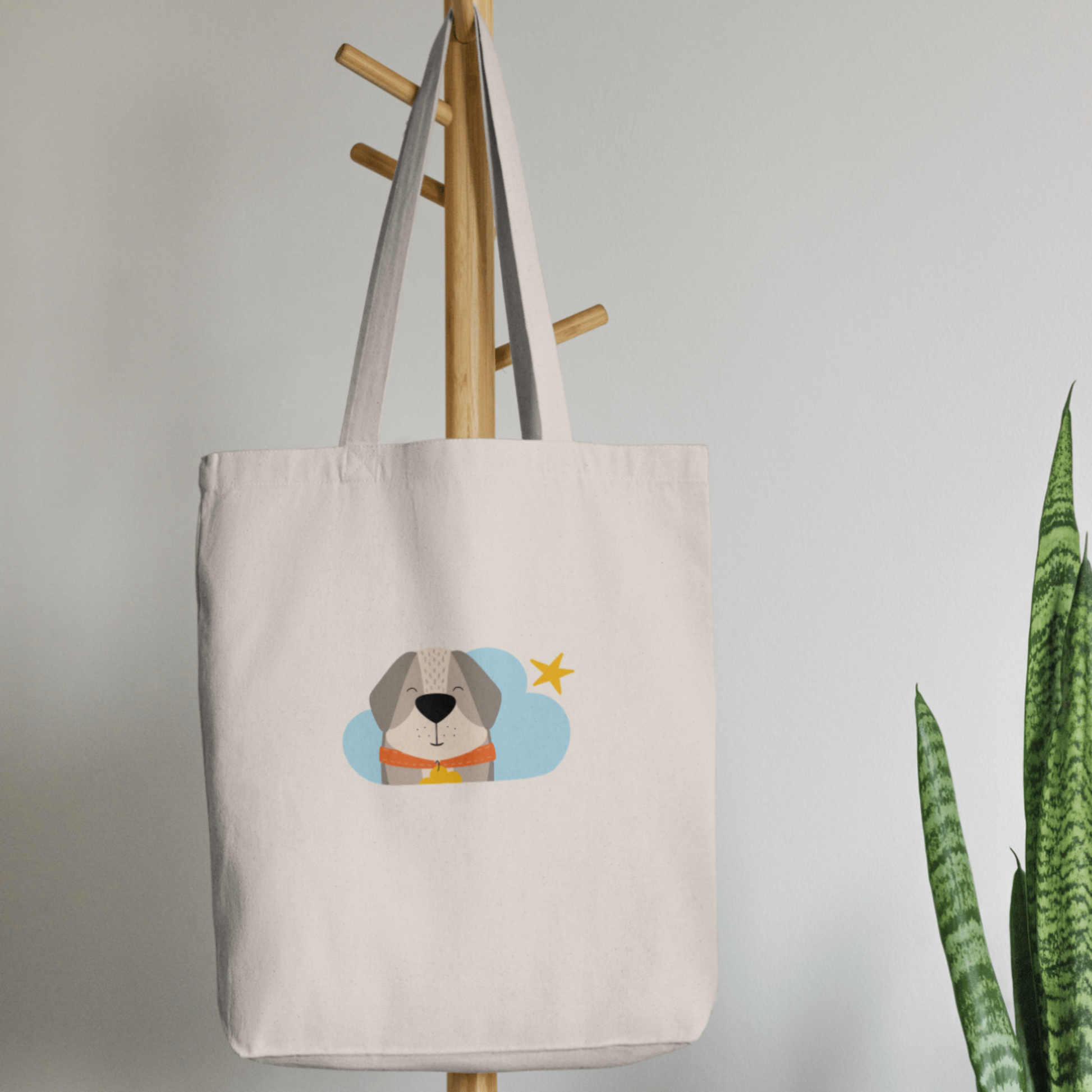 Bolsa Tote Bag color beige en  perchero, mostrando el estampado del perro Leandro en una Nube color azul y una estrella amarilla