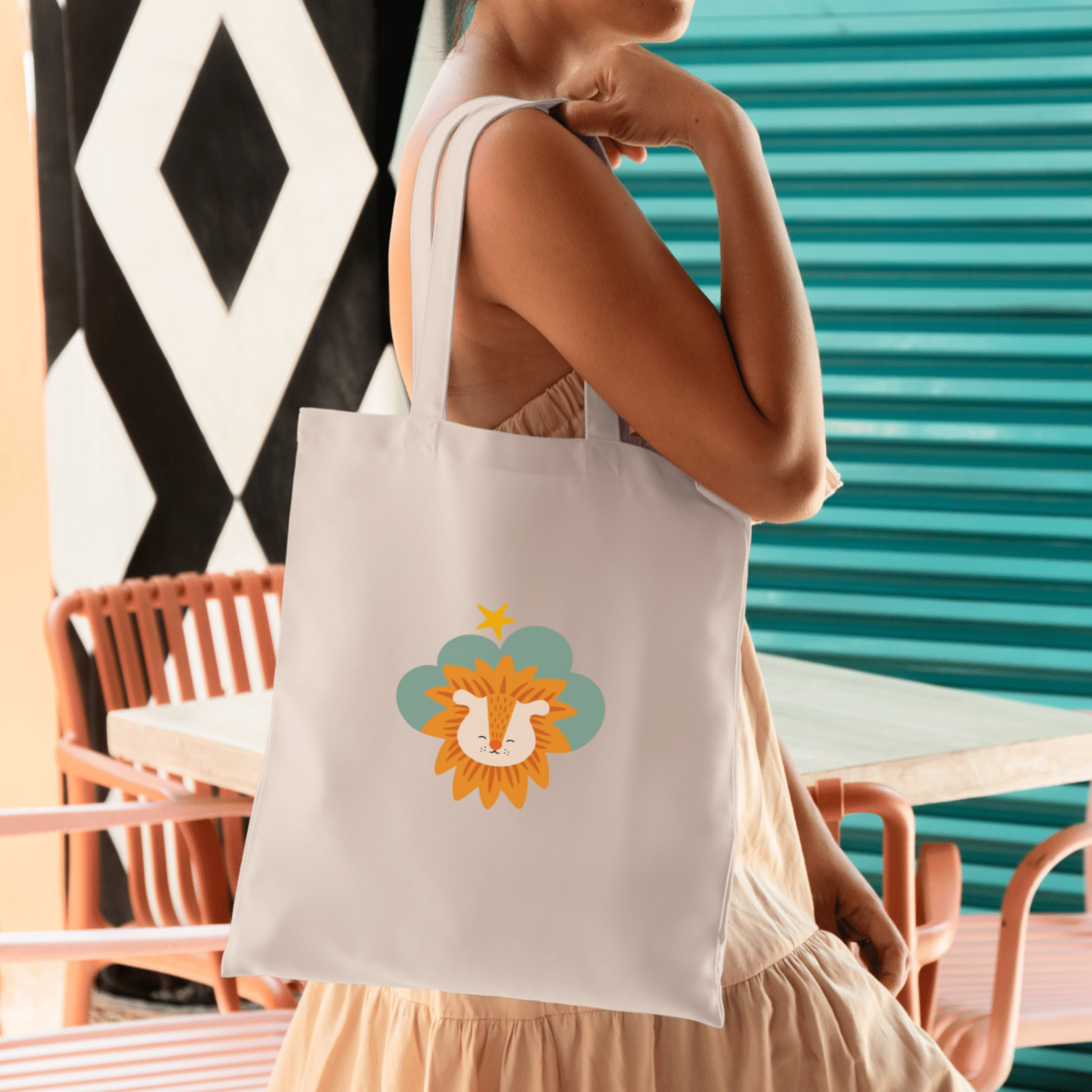 Mujer con vestido ligero sostiene la bolsa tote bag de la marca de ropa nube con estampado de león Sabino en una Nube color verde y una estrella amarilla
