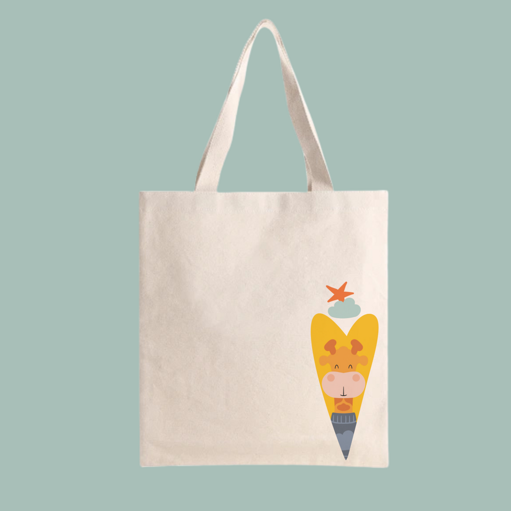 Bolsa Tote Bag color beige con estampado del diseño de la jirafa Lazaro de la marca de ropa nube dentro de un corazón amarillo. Arriba los guía una estrella naranja y una nube azul.